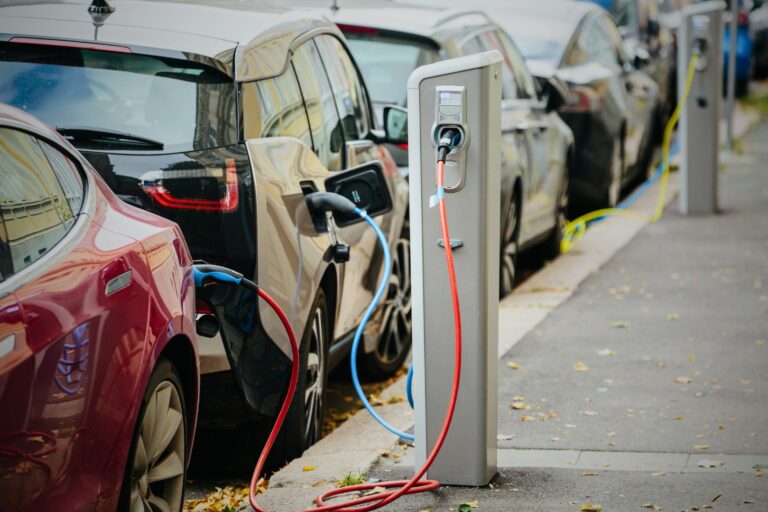 Electric vehicles parked on a street plugged into a charger