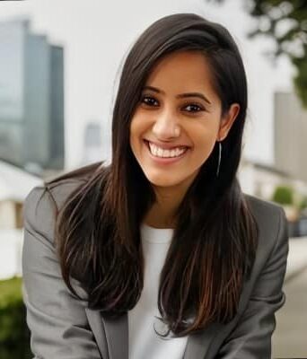 A young woman with long, dark hair smiles at the camera